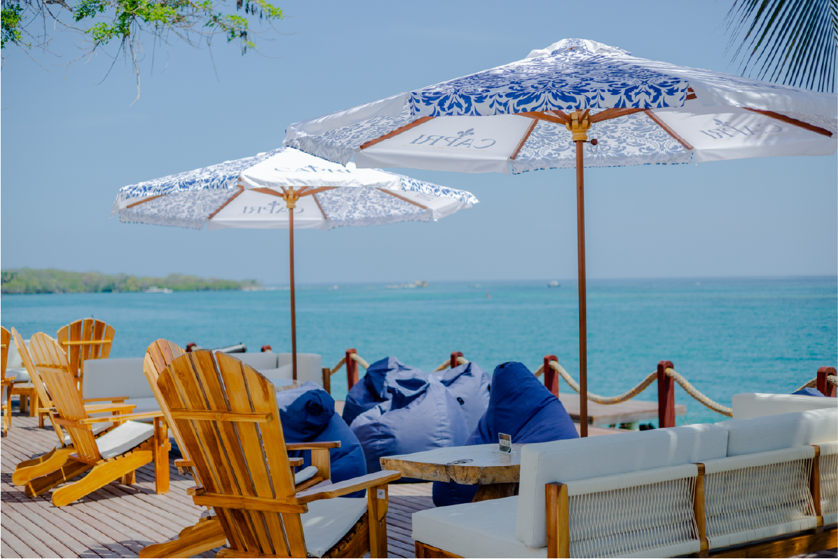 Wooden sun chairs and umbrellas facing the sea at Capri Beach Club