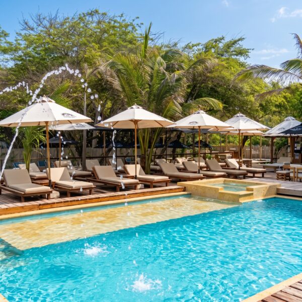 Pool with sun loungers and white umbrellas at Ibbiza Island Beach Club