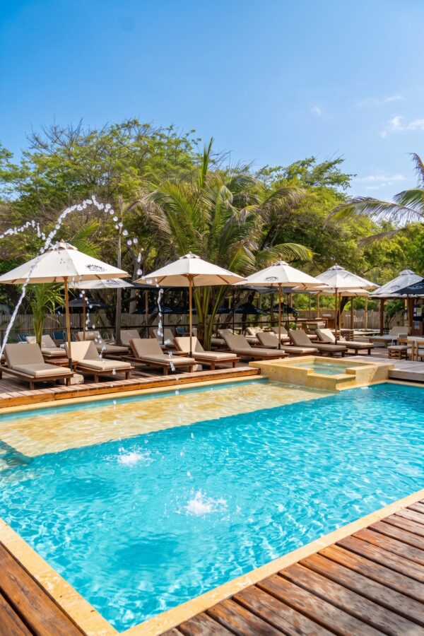 Pool with sun loungers and white umbrellas at Ibbiza Island Beach Club