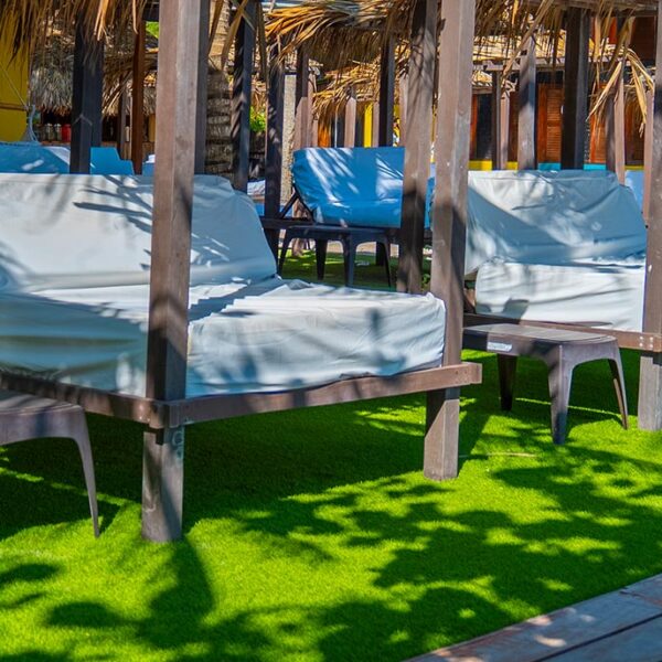 VIP zone with cushioned daybeds under palm shade at Luxury Beach Club