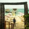 Rustic wooden entrance arch leading to the beach at Luxury Beach Club