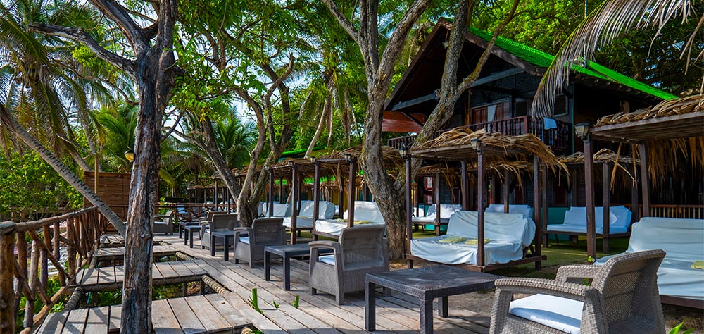 Shaded lounge area under trees at Luxury Beach Club, Rosario Islands