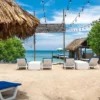 Beach loungers by the thatched huts at Coralina Island