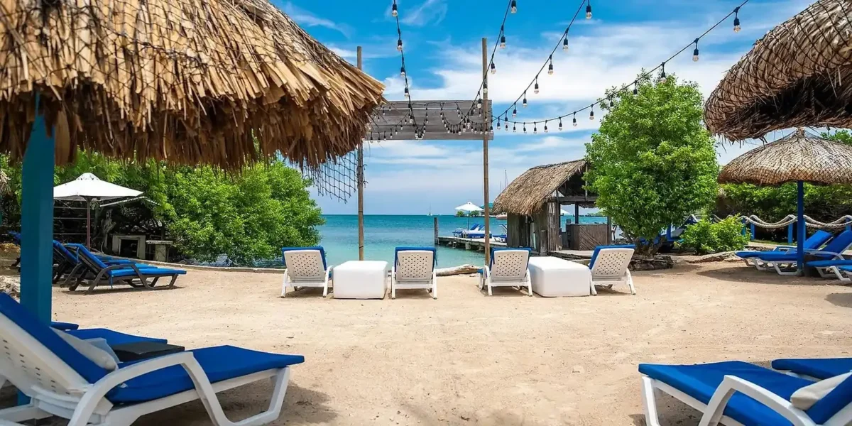 Beach loungers by the thatched huts at Coralina Island