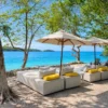 Beachfront lounge beds with umbrellas at Dharma Beach Club