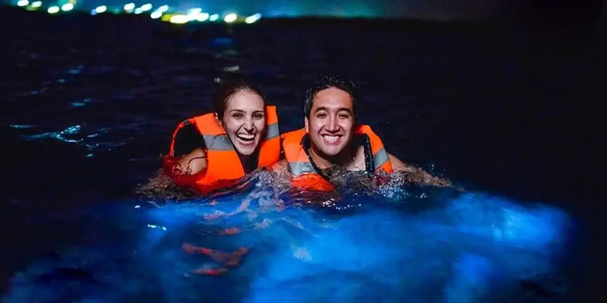 Couple in the bioluminescent plankton at night