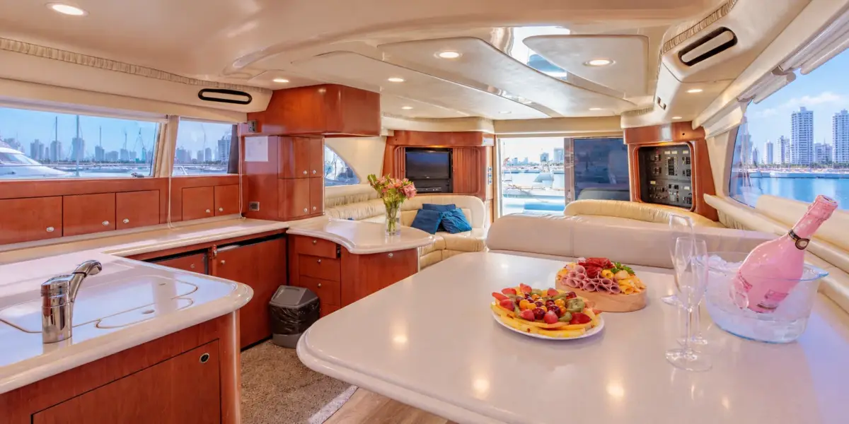 Salon with dining table, kitchen and fruit platter on the Cork Trick yacht