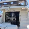 Stern of the Mama's yacht with salon doors and flybridge stairs