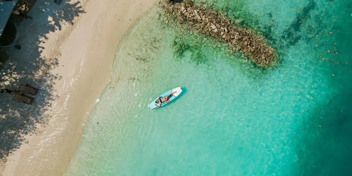 Paddleboarding in turquoise water at Paue Beach Club