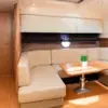 Air-conditioned indoor lounge with sofa and galley on the Zetta yacht